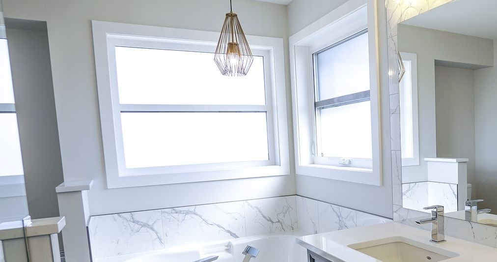 Klassisches, sehr edles Badezimmer in Marmor Optik und weiß matten Fensterbänken.